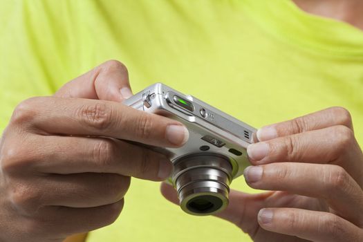 Closeup on hands holding a digital camera while reviewing pictures