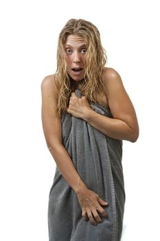 Blond woman with curly hair is surprised and scared while getting out of the shower, grabs her towel. Maybe it's an intruder, or her voyeurist neighbour through the window.
