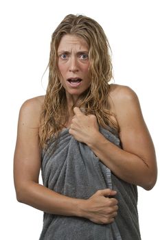 Blond woman with curly hair is surprised and scared while getting out of the shower, grabs her towel. Maybe it's an intruder, or her voyeurist neighbour through the window.