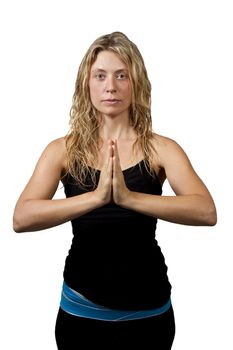 Yoga pose, blond woman in black outfit standing hands joined, looking at the camera