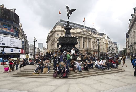London, UK - July 21, 2011: Young people sit on the steps of the recently renovated statue of Cupido on Piccadilly Circus on July 21, 2011 in London, UK.