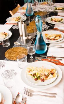 December dinner table, plates with entr�e and blue bottles fresh water