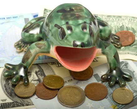 The ceramic frog sits on coins and banknotes.