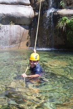 Men in the water pulling the rapel rope after descending