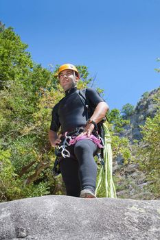 Men staring into horizont and prepering to rappeling into a canyon