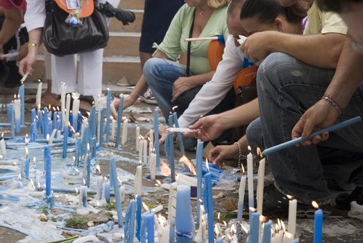 Low angle cropped shot of religious candles being lit on the floor (Iemanja Day in Brazil)