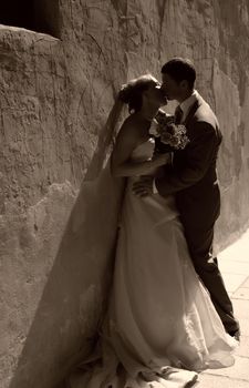 Newly wed couple kissing in the soft rays of setting sun