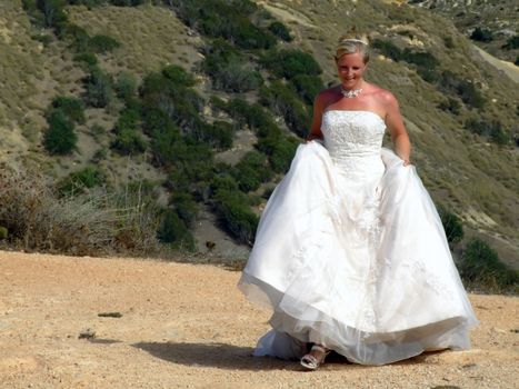 Bride in gown walking in countryside in Malta, full of happiness
