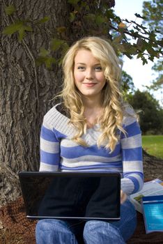 pretty young student typing on a laptop