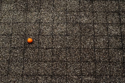 Abandoned orange soccer ball in yard