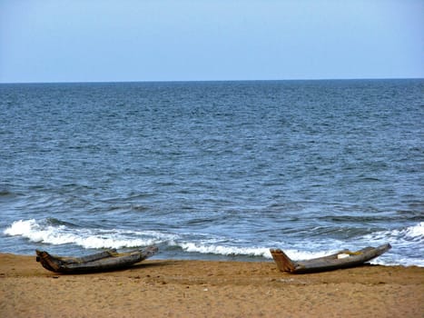 Two boats on the shore of the Bay of Bengal in India.