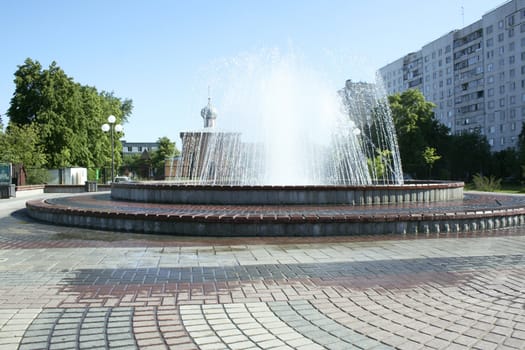 Fountain in the city with church on the background.