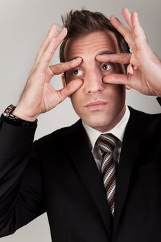 Businessman trying to stay awake by propping his eyes