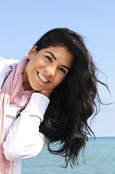 Portrait of beautiful smiling brunette girl at beach being playful