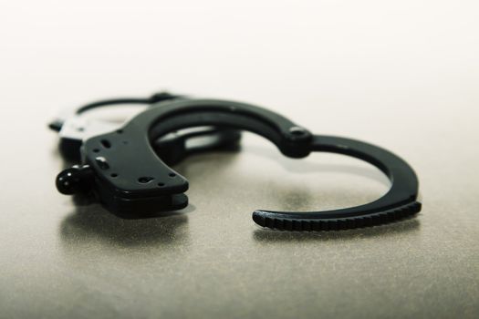 Pair of handcuffs open on a tabletop