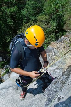 Men prepering to rappeling on waterfall checking is safe line and securety