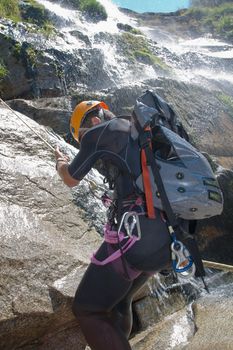 Men descending in rappeling a waterfall