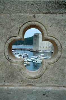 view on the port in Dubrovnik from the hole in bridge - the wall is sharp and the port is blurred