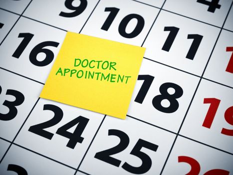 Doctor appointment written on a sticky note on a calendar.