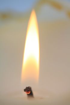 Close up of a burning ivory white candle 