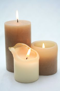 A group of three candles, beige and ivory white