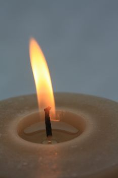 Close up of a beige burning candle