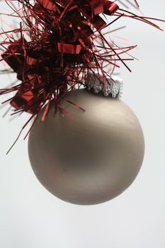 Silver grey christmas ball on a red guirlande