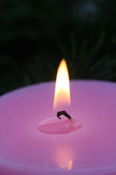 Close up of a burning flame of a pink candle