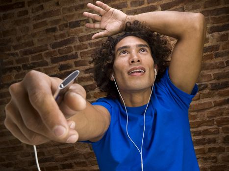 Young man dancing and listening to music on an mp3 player.