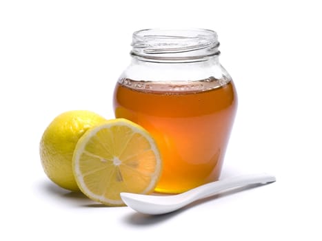 A jar of honey, lemons and spoon. Isolated on white background.