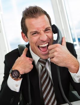 Stressed young businessman screaming on the phone