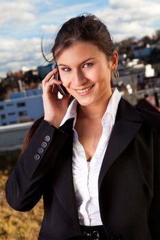 Portrait of beautiful businesswoman talking on cellphone outside