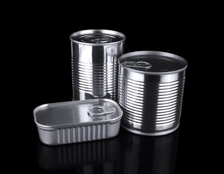 Three different unopened tin cans isolated on black.