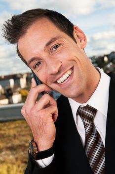 Portrait of businessman talking on cellphone outside