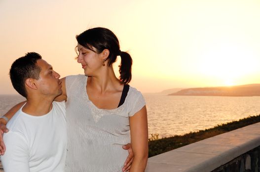 Happy couple and sunset in the background.