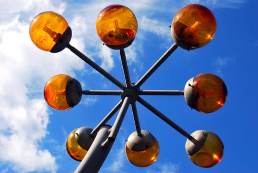 orange glass modern lantern in blue cloudy sky on background