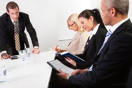 Team of business people taking notes at the meeting