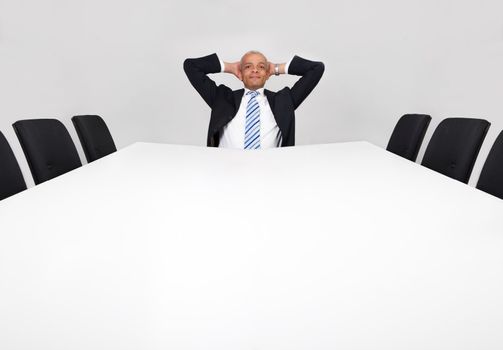 Businessman sitting alone in the empty boardroom