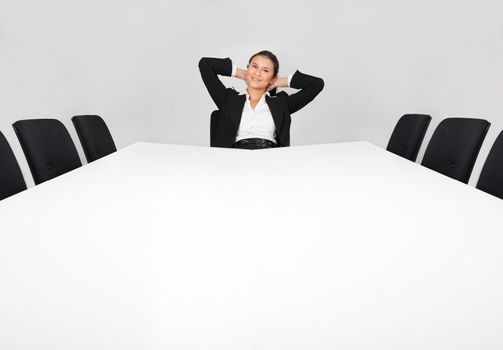 Businesswoman sitting alone in the empty boardroom