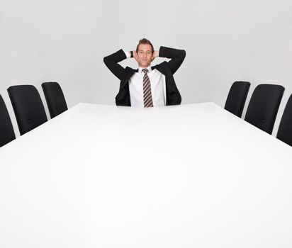 Businessman sitting alone in the empty boardroom