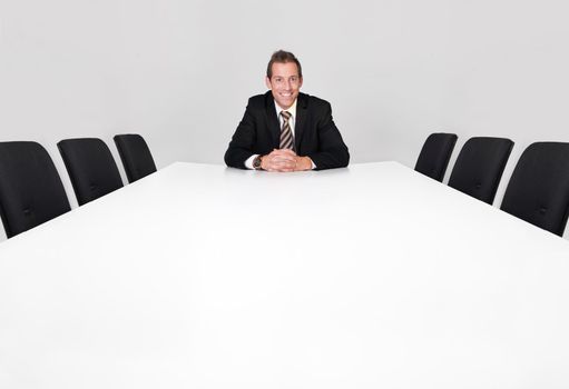 Businessman sitting alone in the empty boardroom