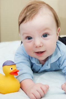 Smiling baby boy and duck toy