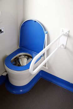 toilet in train with handle for handicapped people