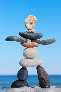 Artistic figurine of stones on the against blue sky