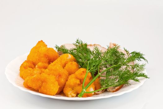 Rosted cauliflower with hot smoked chiken meat and fresh dill on white porcelain plate
