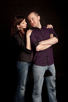 Woman embracing her sad boyfriend. Studio shot