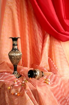 Two bronze Indian vases on a red fabric