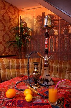 Cosy table with a hookah and the fruit, issued in east style