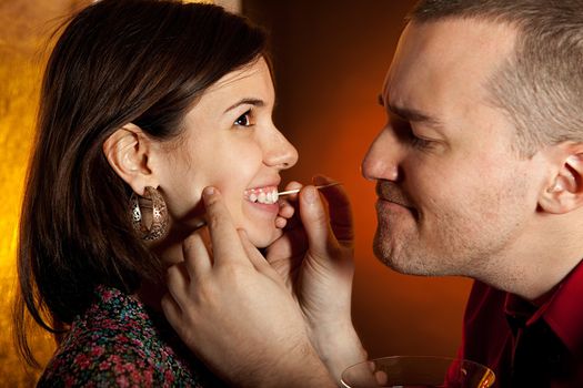 Men taking care of girlfriend's teeth. Focus on the girls eye