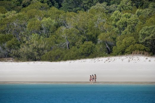 Three Girls wlking in Whitehaven Beach in the Whitsunday Islands